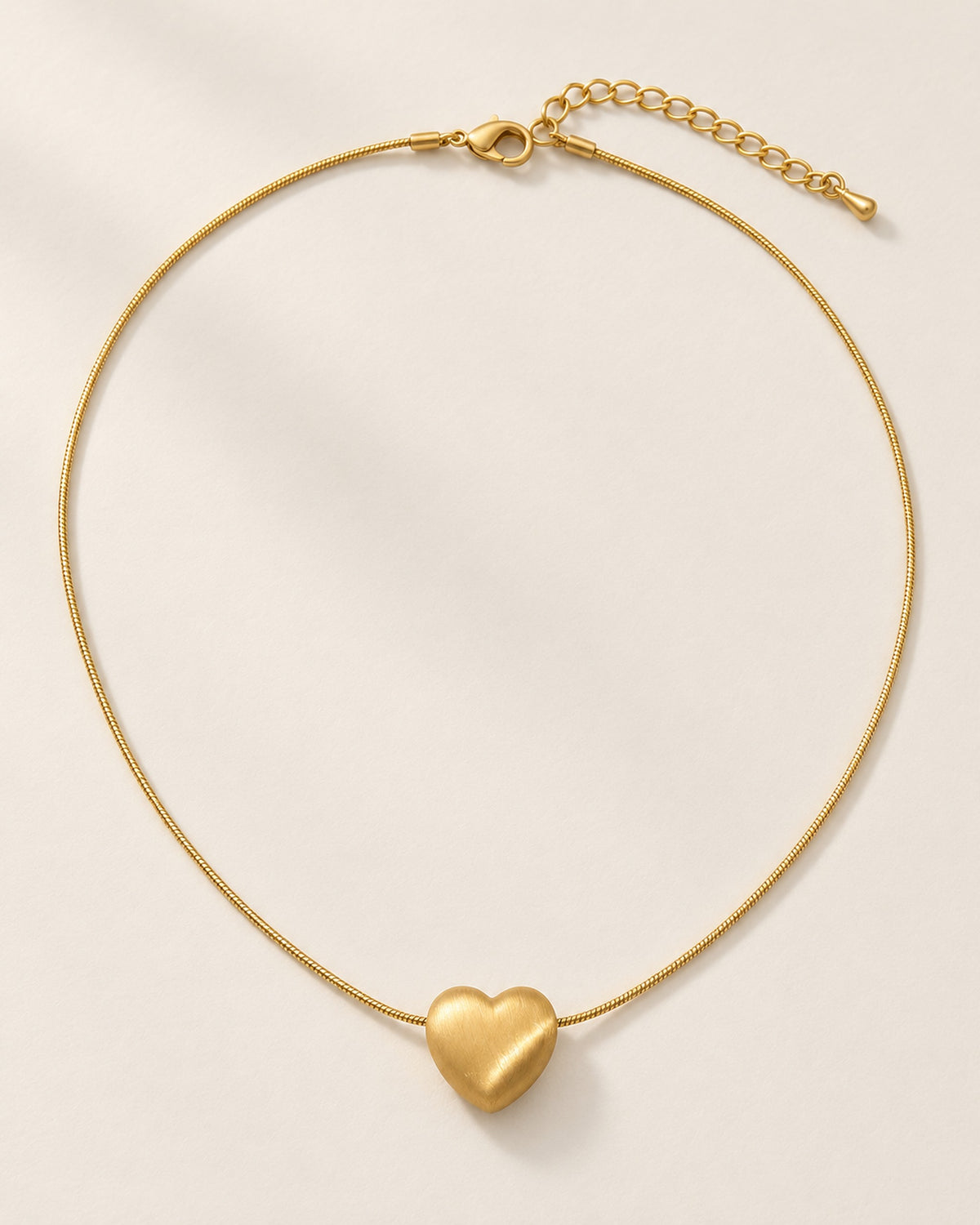 Héloïse brushed matte heart pendant necklace on snake chain in Gold, three-quarter view