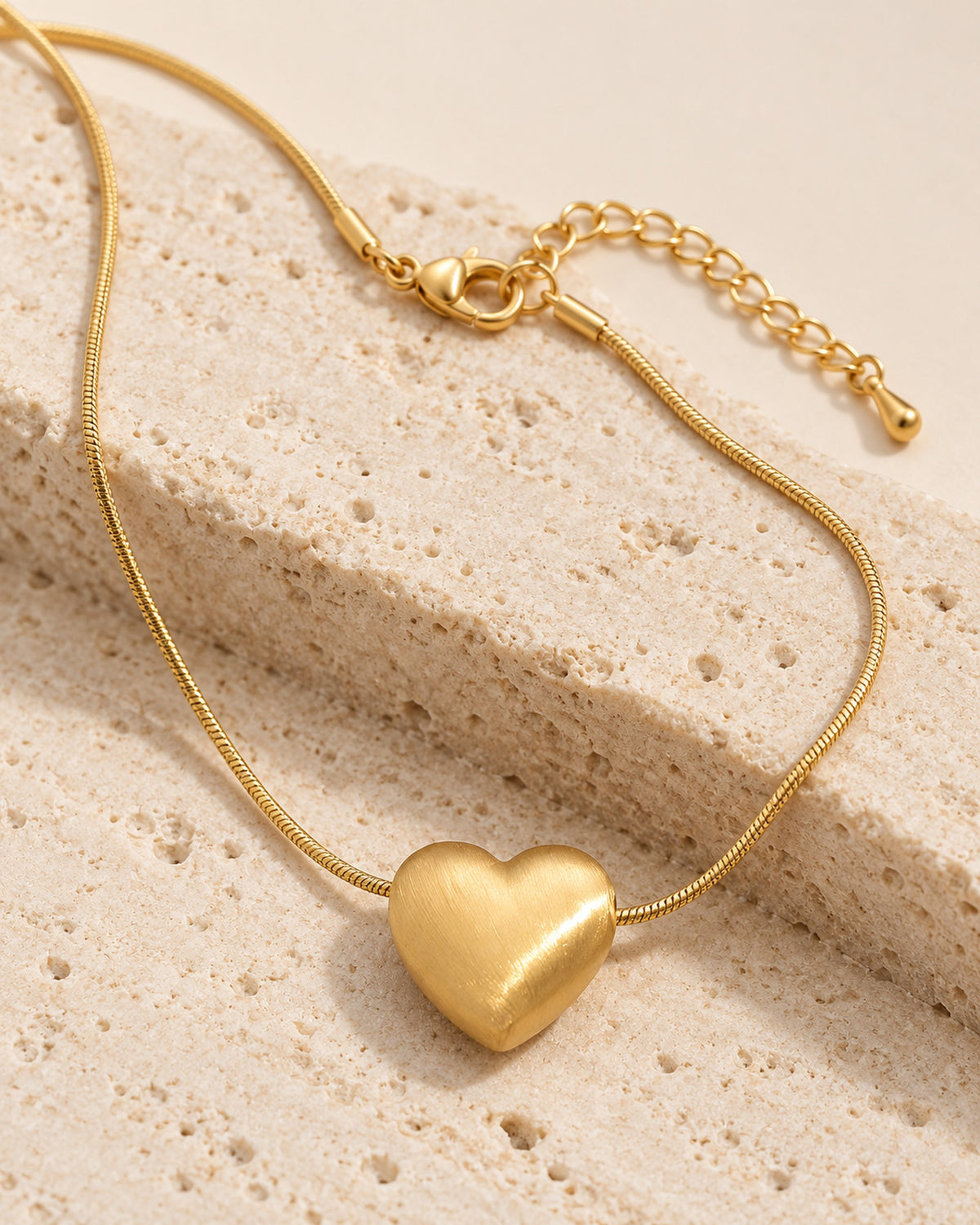 Héloïse brushed matte heart pendant necklace on snake chain in Gold, close-up detail
