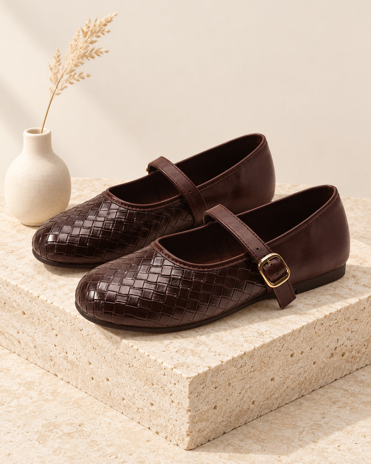 Adèle woven leather Mary Jane flat with buckle strap in Brown, still life on travertine