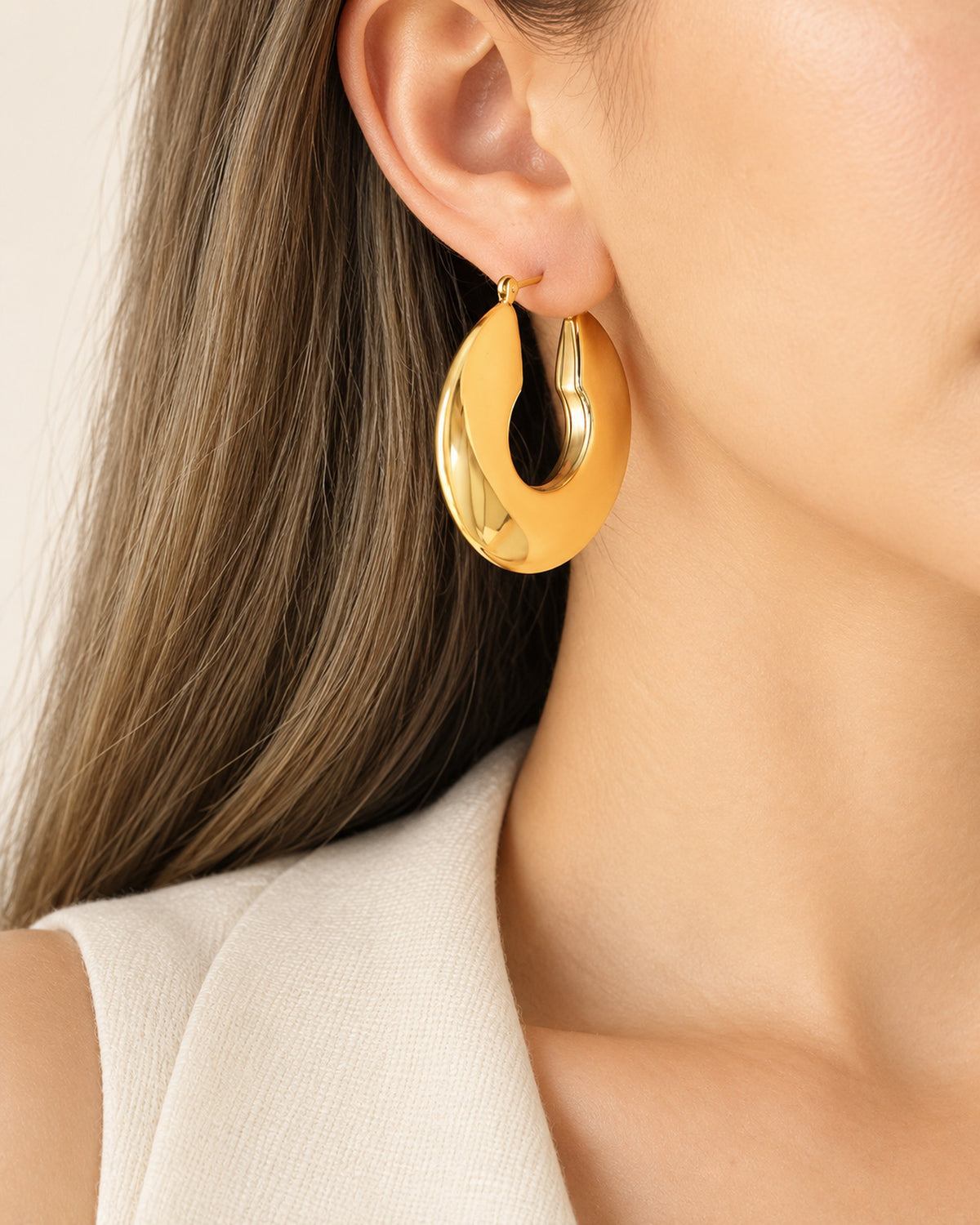 Aurélie sculpted oval hoop earrings in Gold, worn