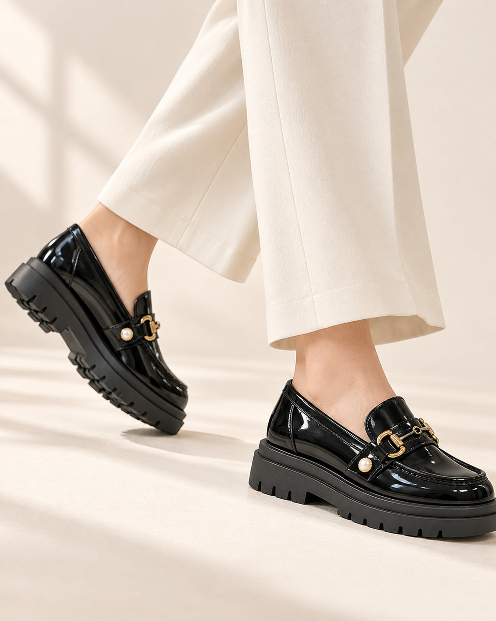 Bérénice patent-finish platform loafer with horsebit buckle in Black, in motion