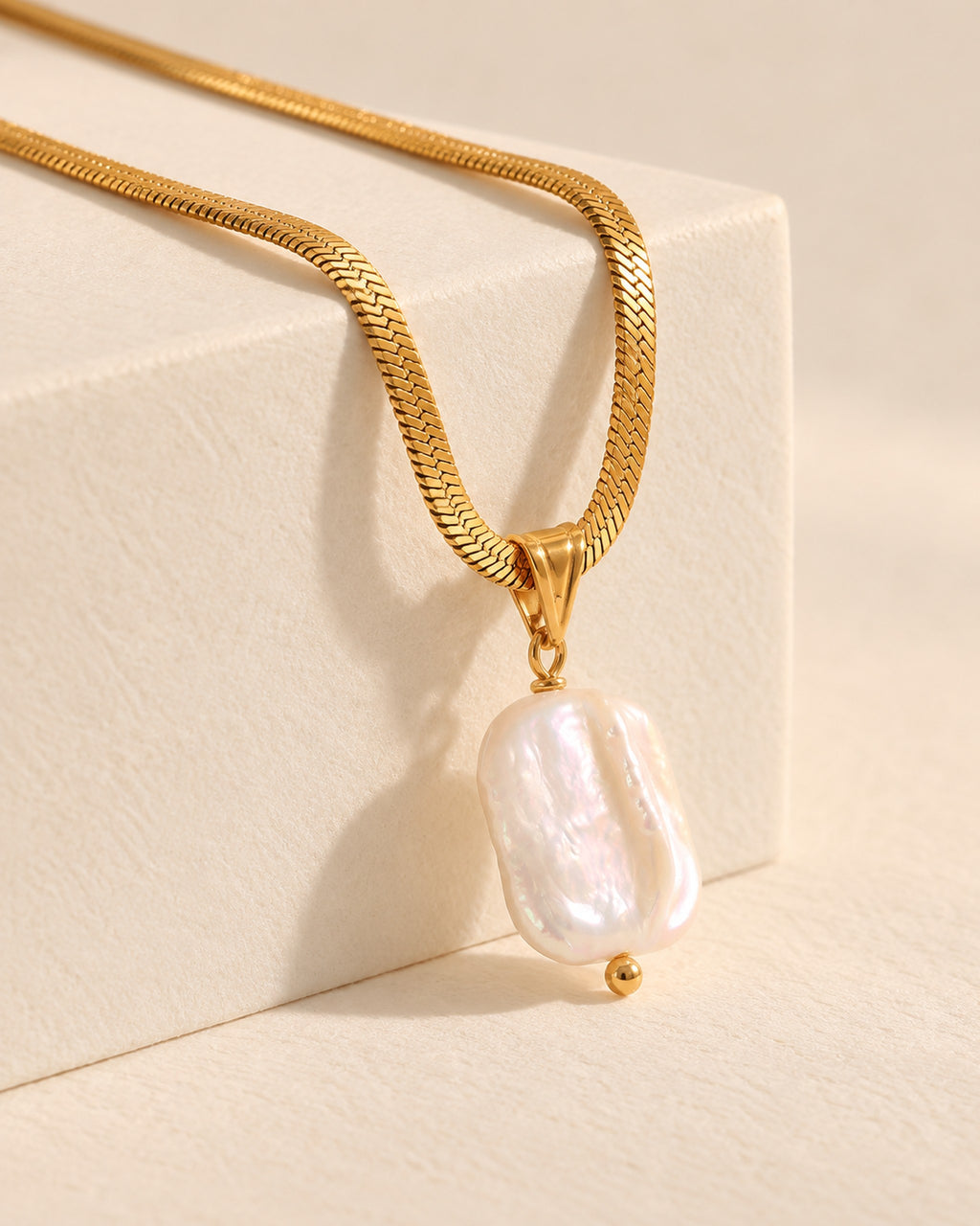 Celeste gold-tone herringbone chain necklace with baroque pearl drop, side view