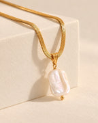 Celeste gold-tone herringbone chain necklace with baroque pearl drop, side view