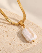 Celeste gold-tone herringbone chain necklace with baroque pearl drop, close-up detail