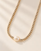 Celeste gold-tone crystal tennis chain necklace with oval pearl, three-quarter view