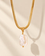 Celeste gold-tone herringbone chain necklace with baroque pearl drop, editorial view