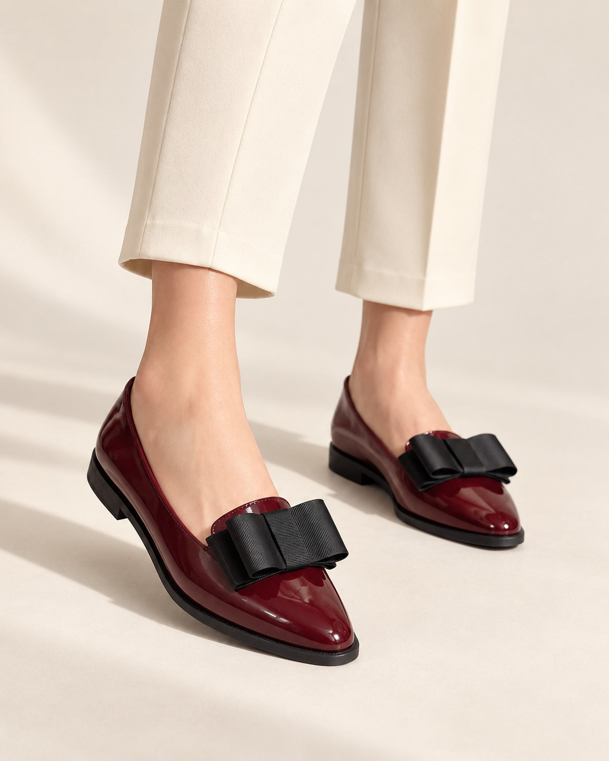 Léa patent-finish pointed ballet flat with oversized bow in Burgundy, worn