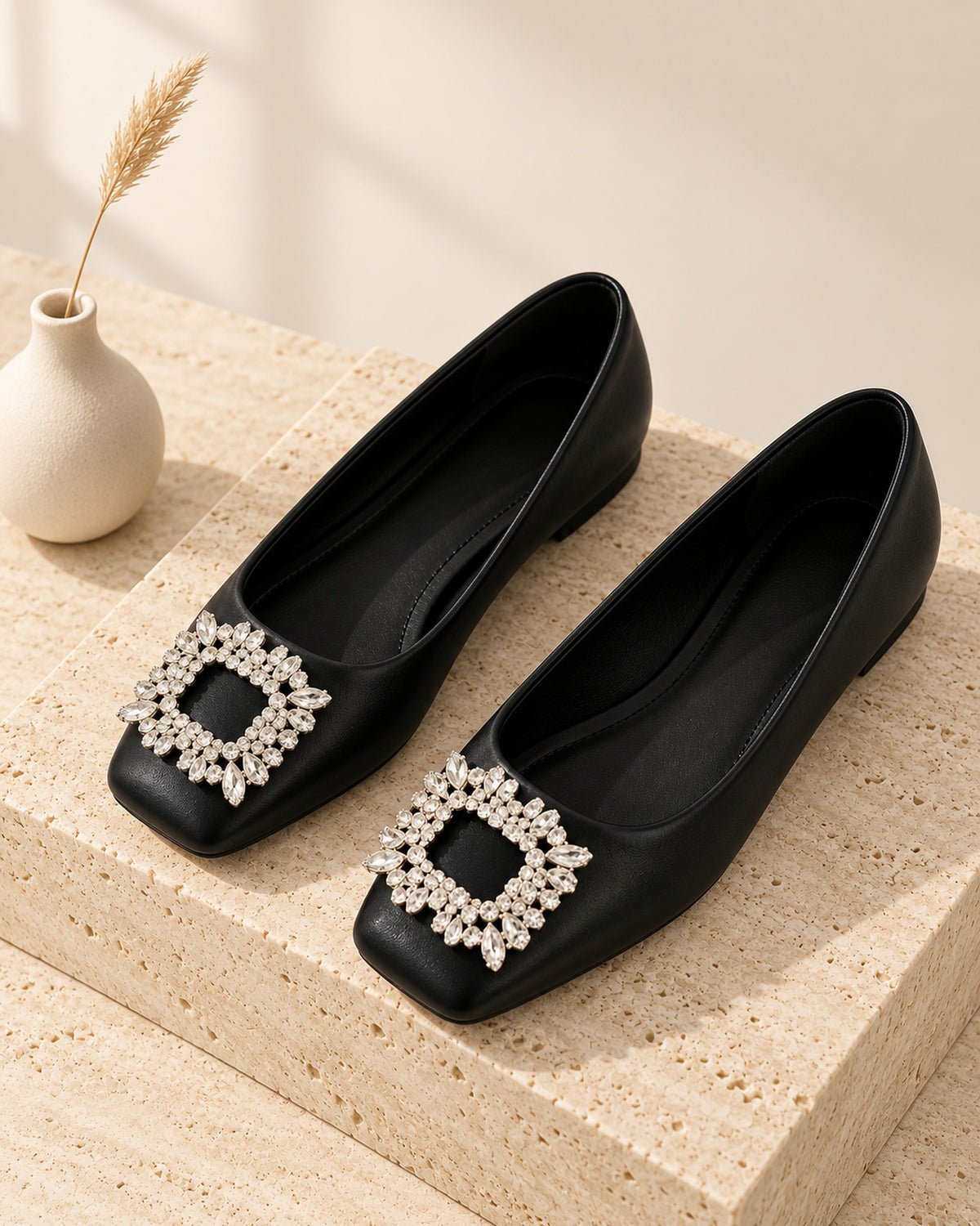 Lysiane square-toe flat with rhinestone buckle in Black, still life on travertine