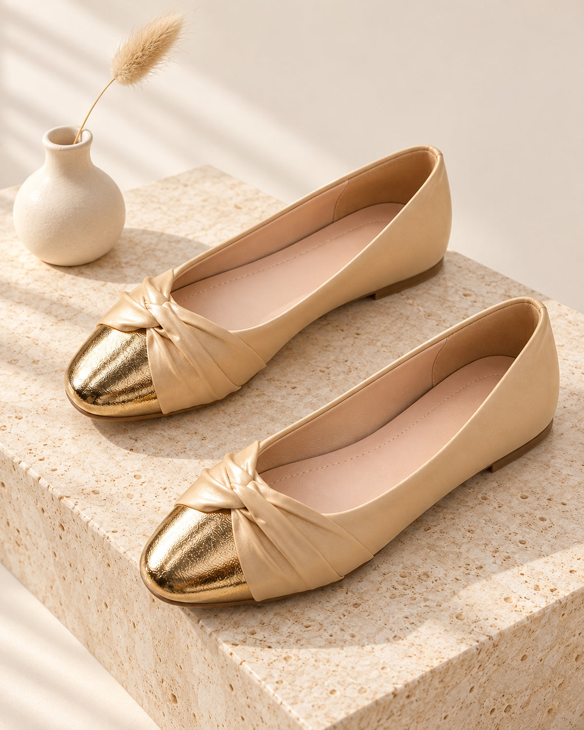 Élodie satin ballet flat with knotted vamp and metallic toe cap in Beige, still life on travertine